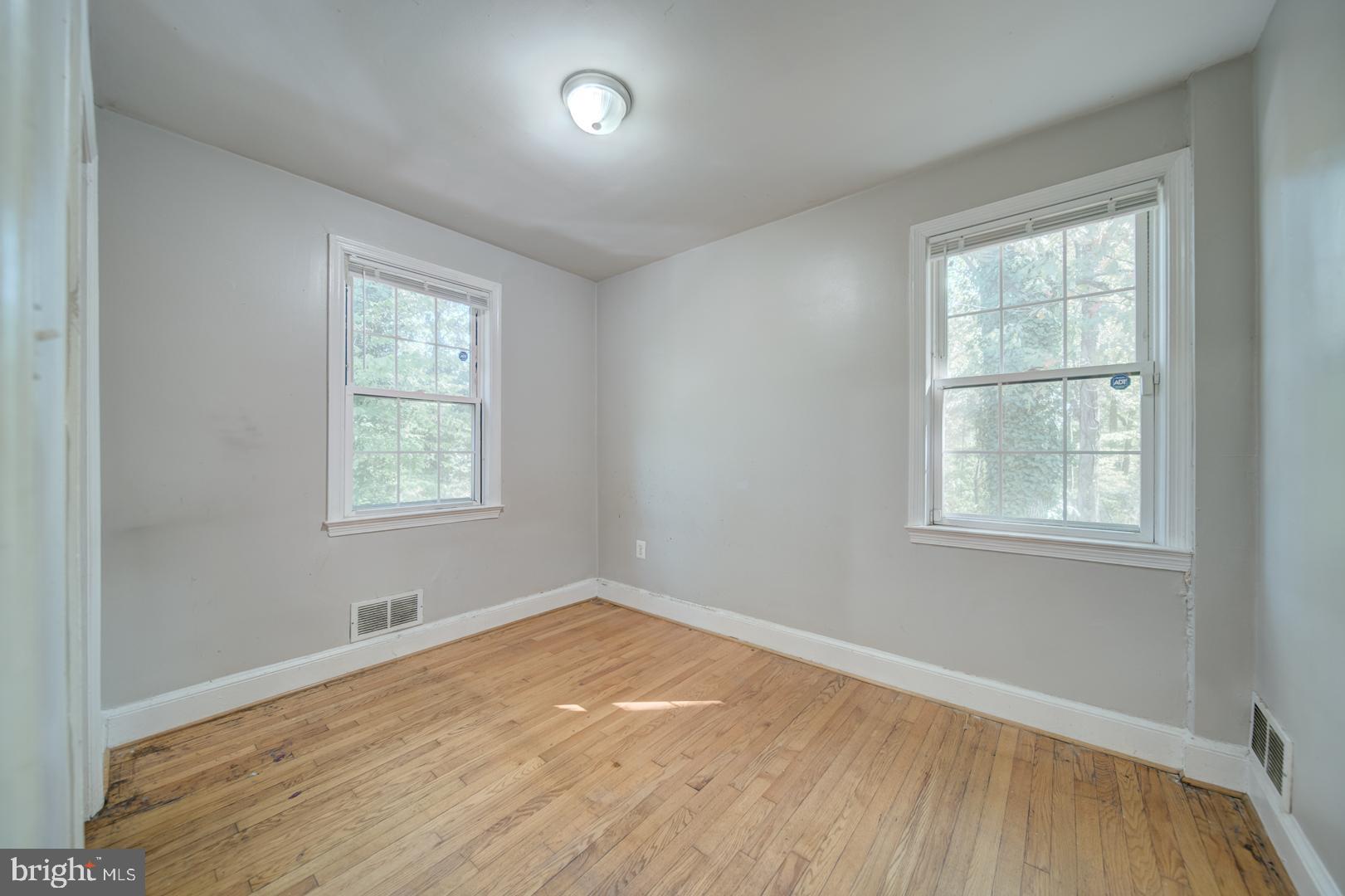 802 Modoc Lane Oxon Hill, MD 20745 - Photo 16 of 34 an empty room with wooden floor and windows