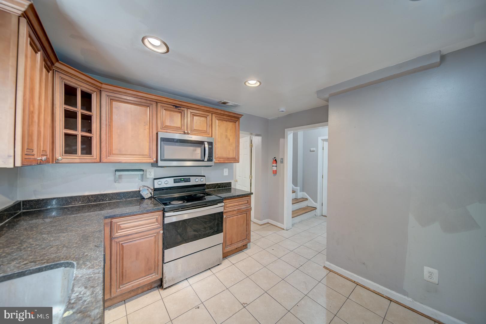 802 Modoc Lane Oxon Hill, MD 20745 - Photo 29 of 34 a kitchen with granite countertop a stove top oven and cabinets