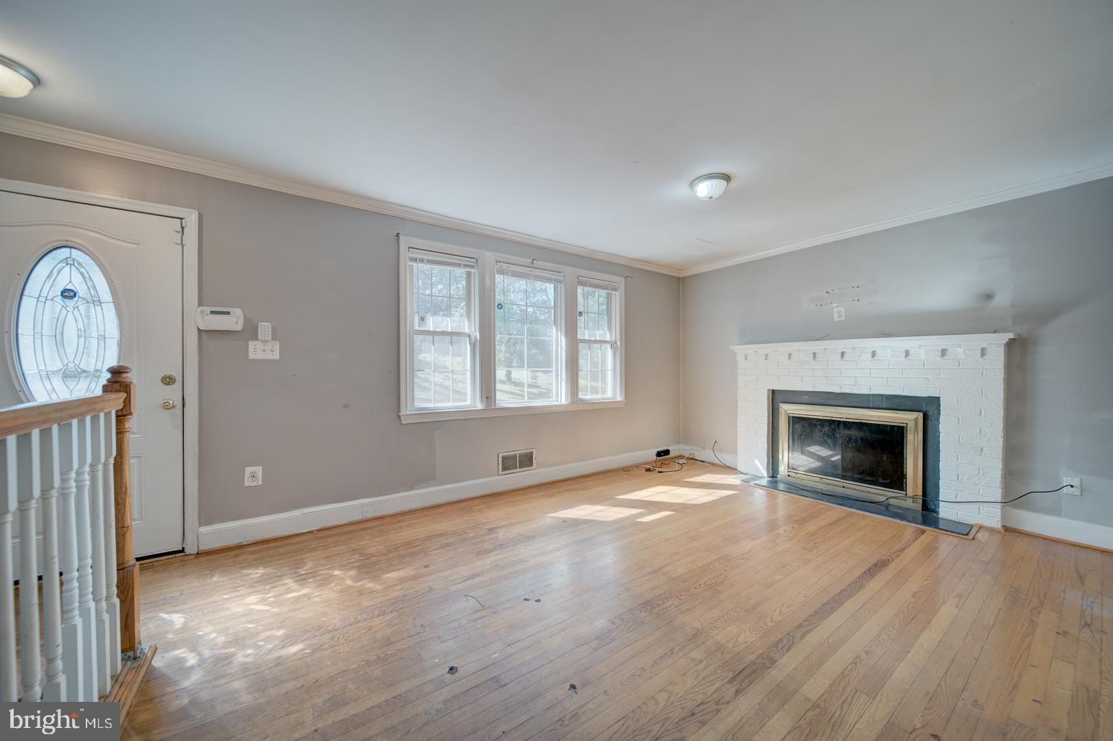 802 Modoc Lane Oxon Hill, MD 20745 - Photo 10 of 34 an empty room with windows fireplace and wooden floor