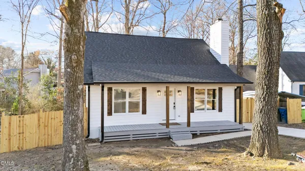 a front view of a house with a tree