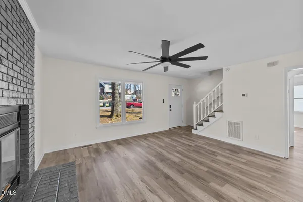 a view of a livingroom with wooden floor and a ceiling fan