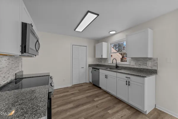 a kitchen with granite countertop a sink and cabinets