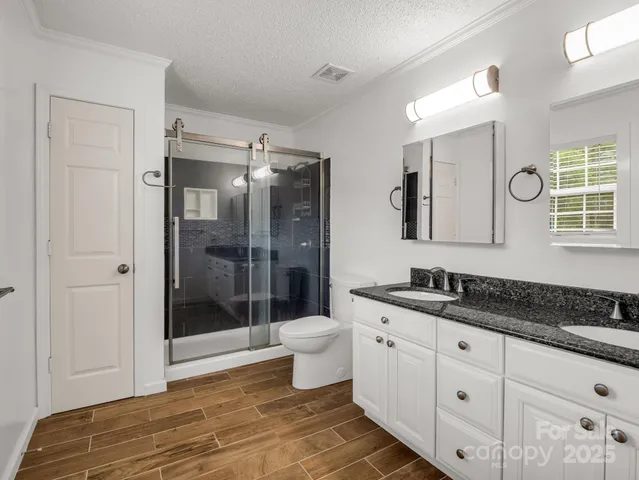 a spacious bathroom with a granite countertop sink toilet and shower