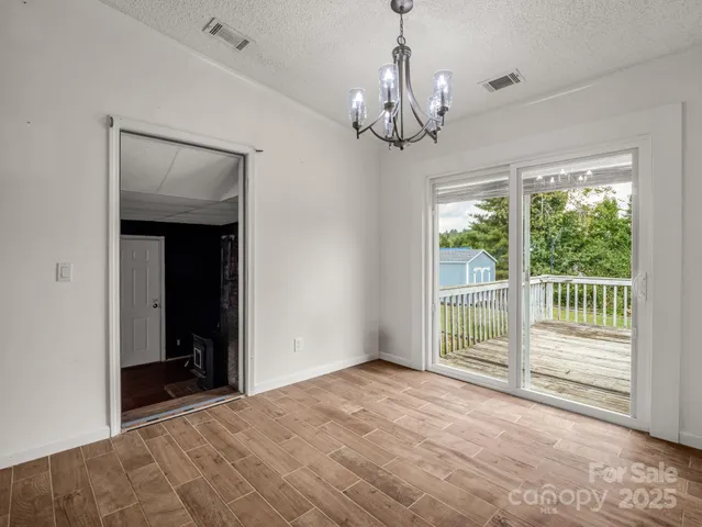 a view of a livingroom with a chandelier curtains and large windows