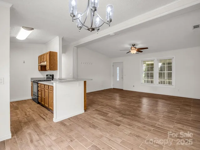a view of kitchen with granite countertop cabinets and window