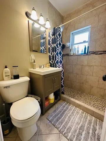 a bathroom with a sink a toilet and shower