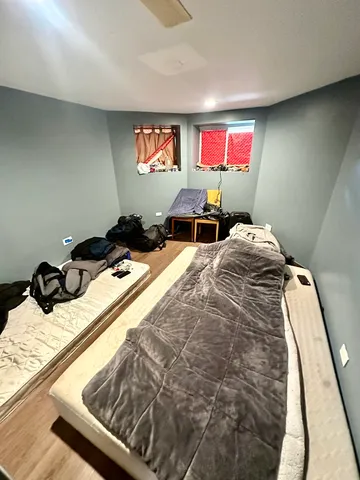 a bed room with two bed and a chair