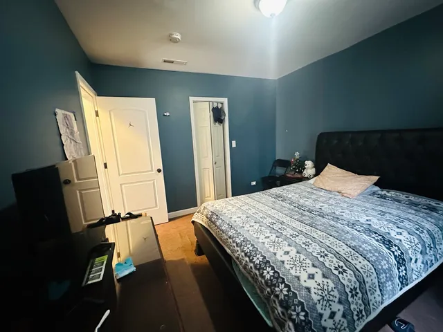 a bedroom with bed and wooden floor