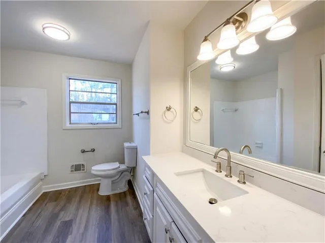 a bathroom with a sink a toilet and a mirror