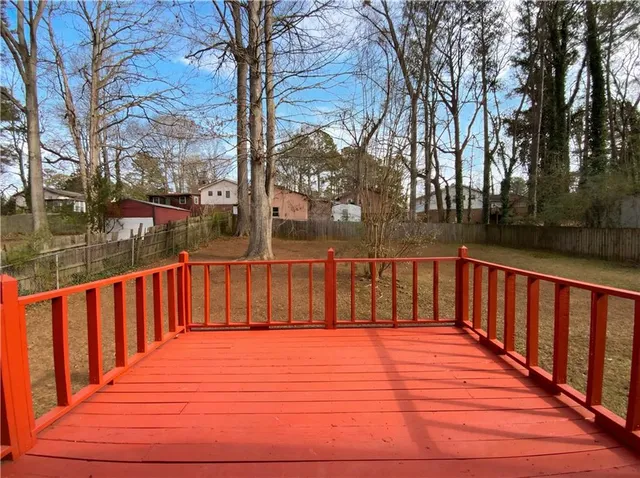 a balcony with wooden floor and trees