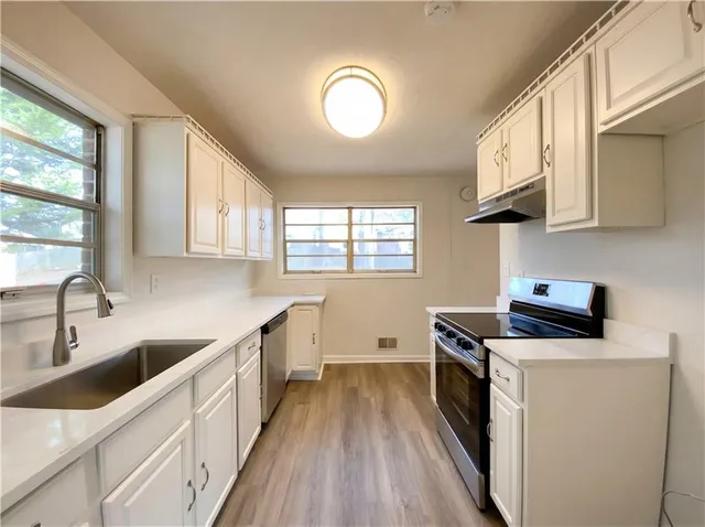 a kitchen with sink a microwave and cabinets