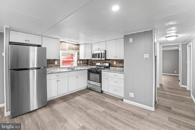 a kitchen with white cabinets and white appliances