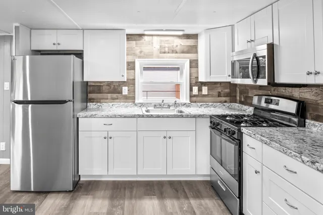 a kitchen with stainless steel appliances granite countertop a refrigerator sink and stove