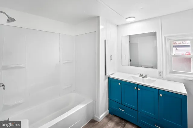a bathroom with a tub sink and mirror
