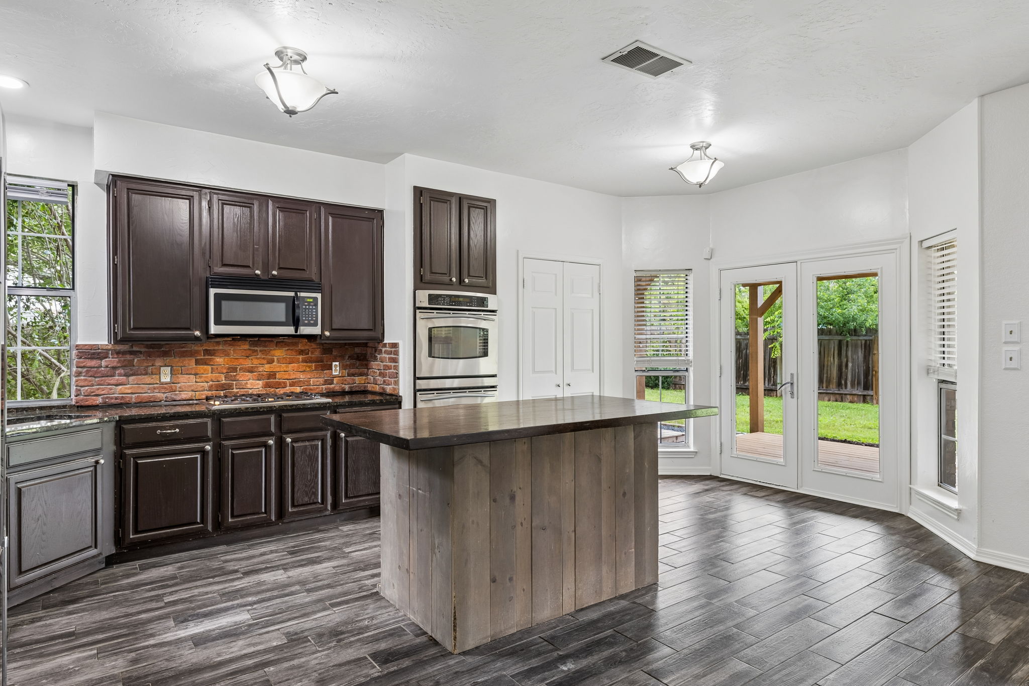 10400 O'Rourk Lane Austin, TX 78739 - Photo 7 of 33 a kitchen with stainless steel appliances granite countertop a stove top oven a sink dishwasher a refrigerator and cabinets with wooden floor