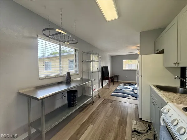 a large kitchen with kitchen island a large counter space a sink a window and stainless steel appliances