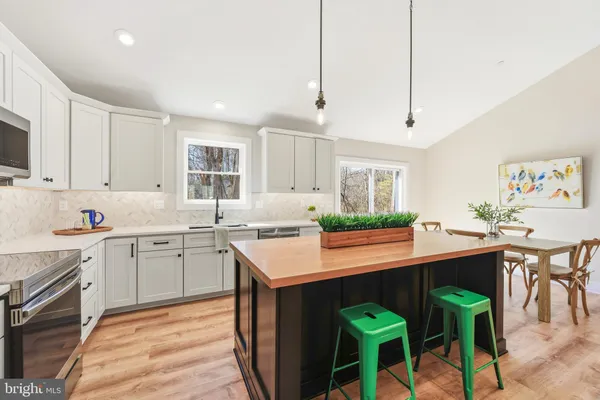 a kitchen with kitchen island granite countertop lots of counter top space and wooden floor