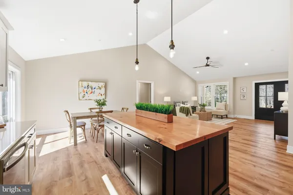 a kitchen with stainless steel appliances kitchen island granite countertop a table chairs and a refrigerator