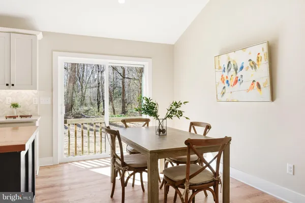 a kitchen with kitchen island a stove a counter top space a sink cabinets and wooden floor