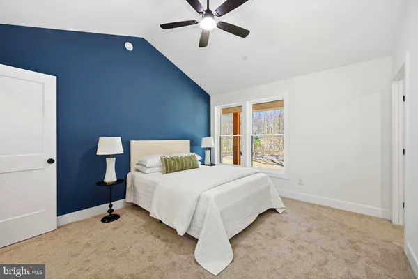 a bedroom with a bed ceiling fan and a window