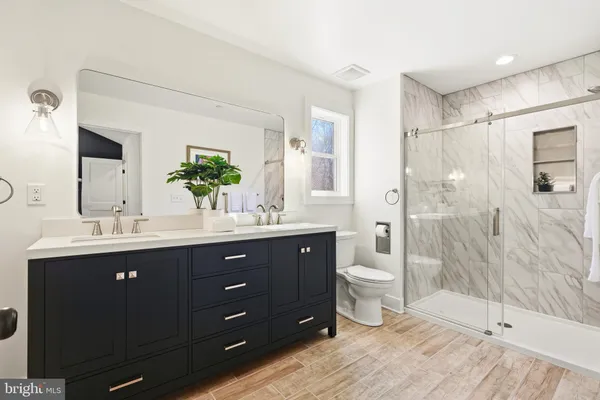 a bathroom with a granite countertop sink mirror and shower