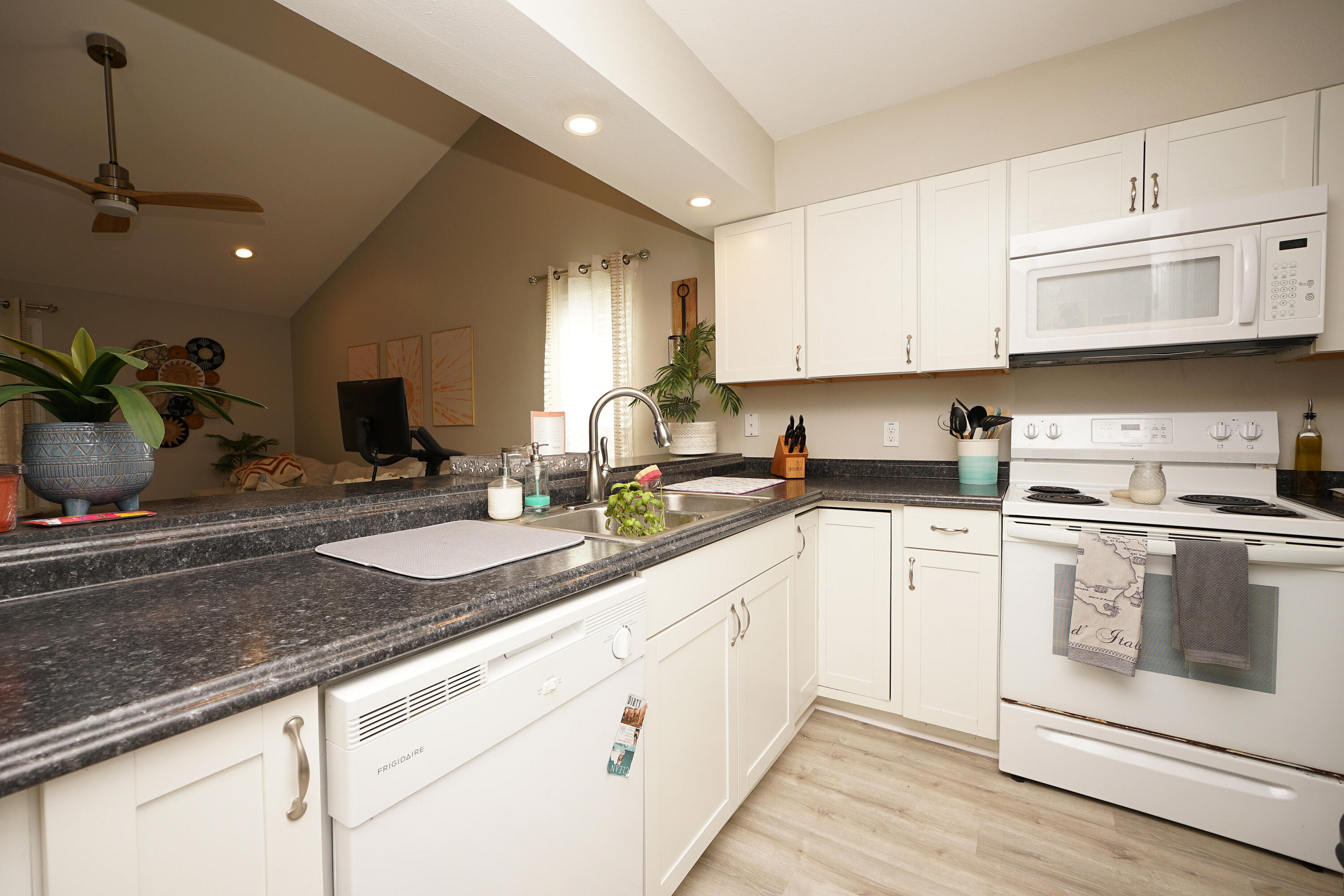 1503 Green Acres Boulevard, Unit E Fort Walton Beach, FL 32547 - Photo 8 of 25 a kitchen with granite countertop a sink stainless steel appliances and white cabinets