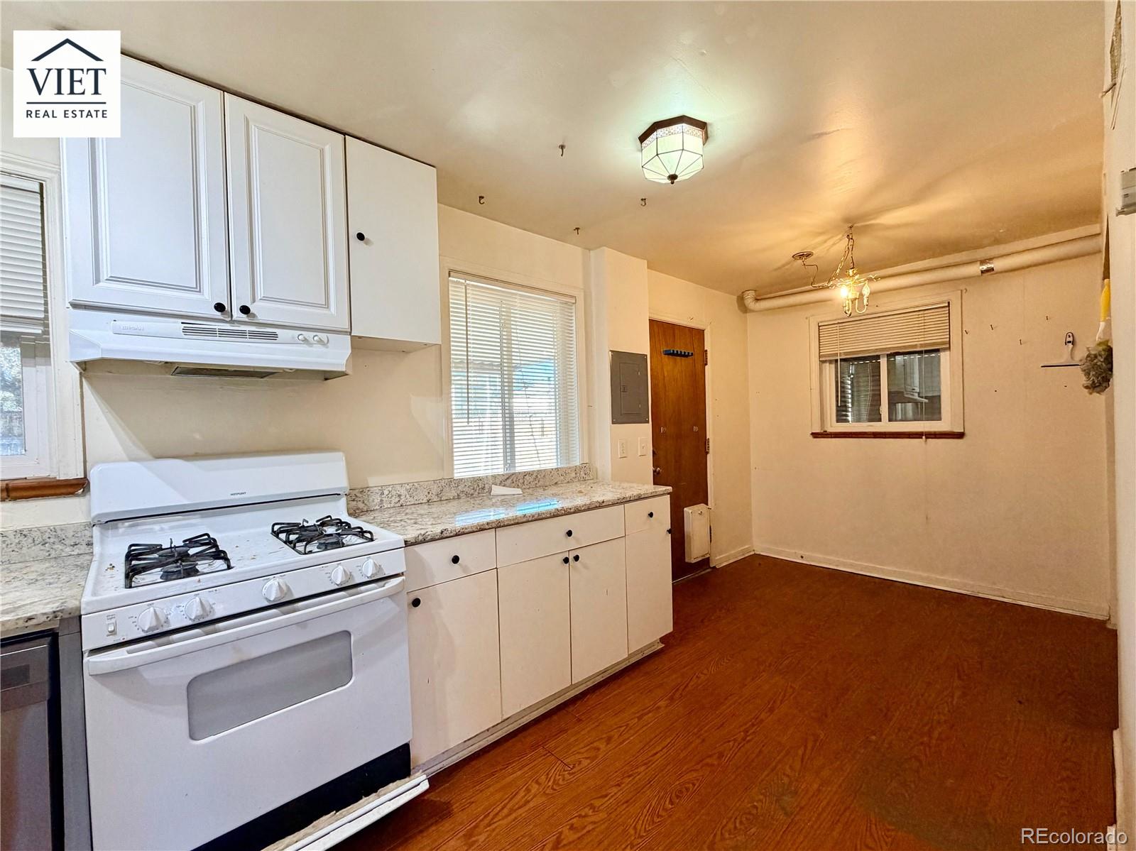 1055 Leyden Street Denver, CO 80220 - Photo 2 of 5 a kitchen with granite countertop white cabinets and white appliances