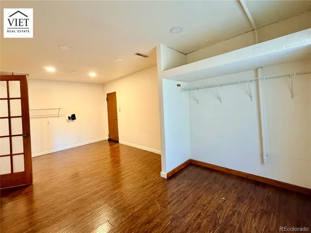 a view of an empty room with wooden floor