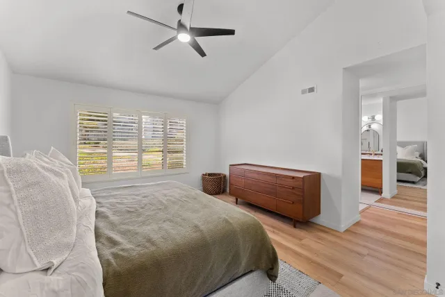 a bedroom with bed and wooden floor