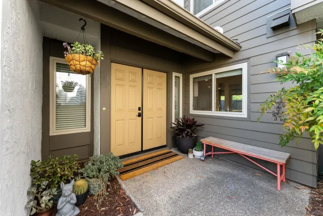 a house with a lot of flower plant in front of it