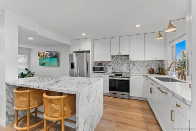 a kitchen with kitchen island granite countertop wooden cabinets and stainless steel appliances
