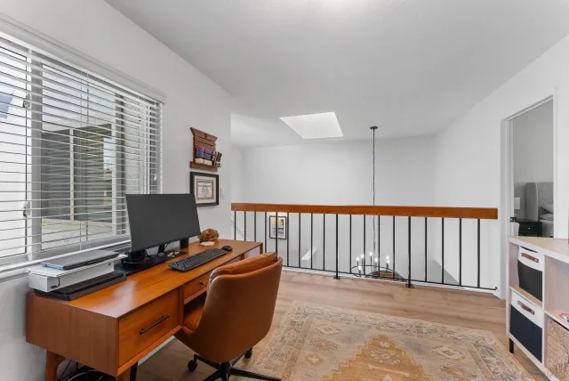a view of a workspace with furniture and a window