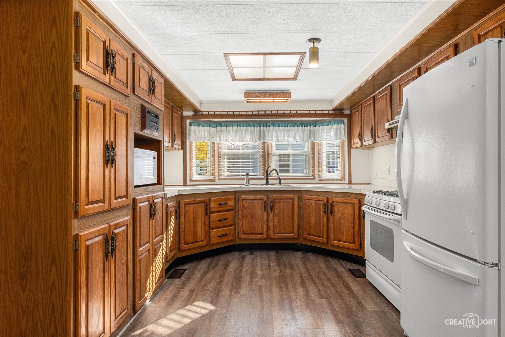 1122 Candida Road Elgin, IL 60123 - Photo 6 of 16 a kitchen with stainless steel appliances granite countertop a refrigerator a stove and a sink with wooden floors