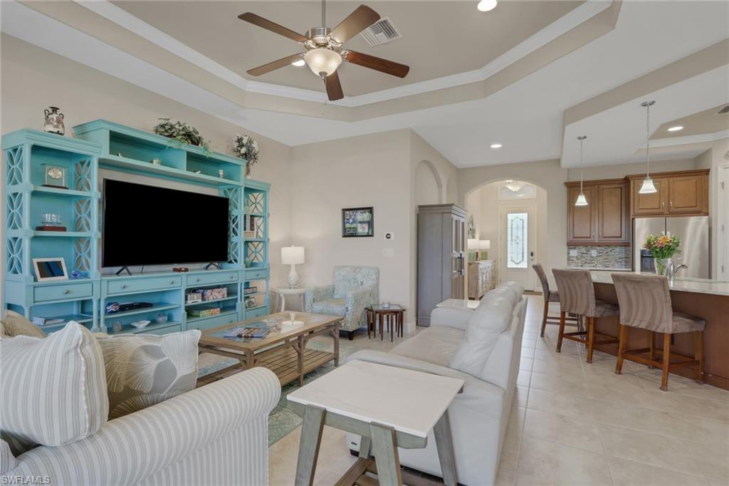 1589 Serrano Circle Naples, FL 34105 - Photo 11 of 38 a living room with furniture and a flat screen tv