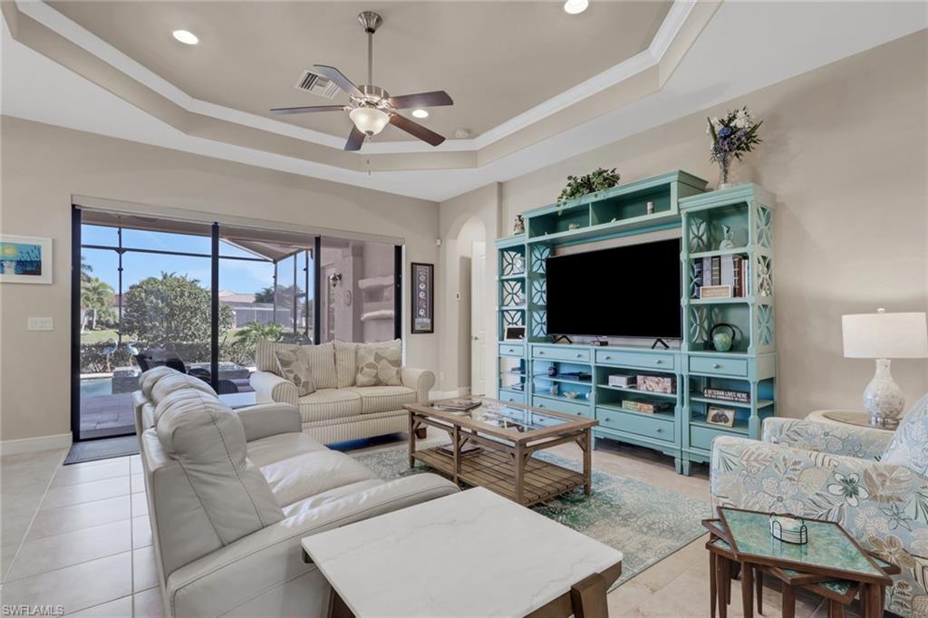 1589 Serrano Circle Naples, FL 34105 - Photo 12 of 38 a living room with furniture and a flat screen tv