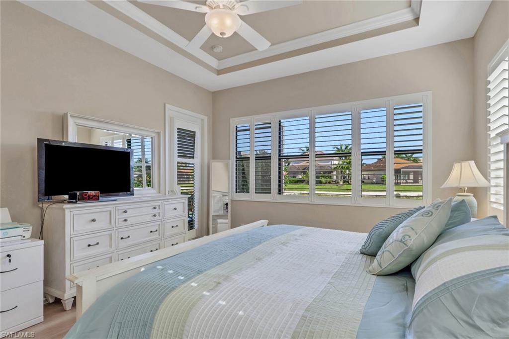 1589 Serrano Circle Naples, FL 34105 - Photo 14 of 38 a bed room with a bed a television and a large window