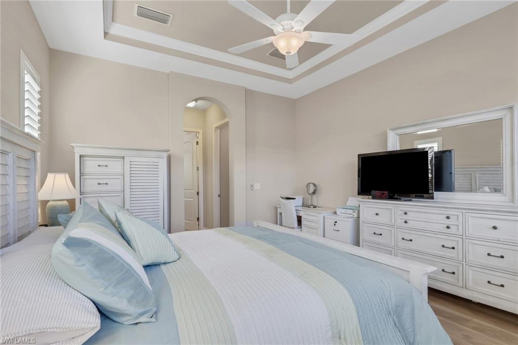 1589 Serrano Circle Naples, FL 34105 - Photo 15 of 38 a bedroom with a bed and a flat screen tv