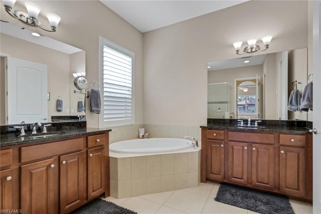 1589 Serrano Circle Naples, FL 34105 - Photo 16 of 38 a bathroom with a sink double vanity granite and a mirror