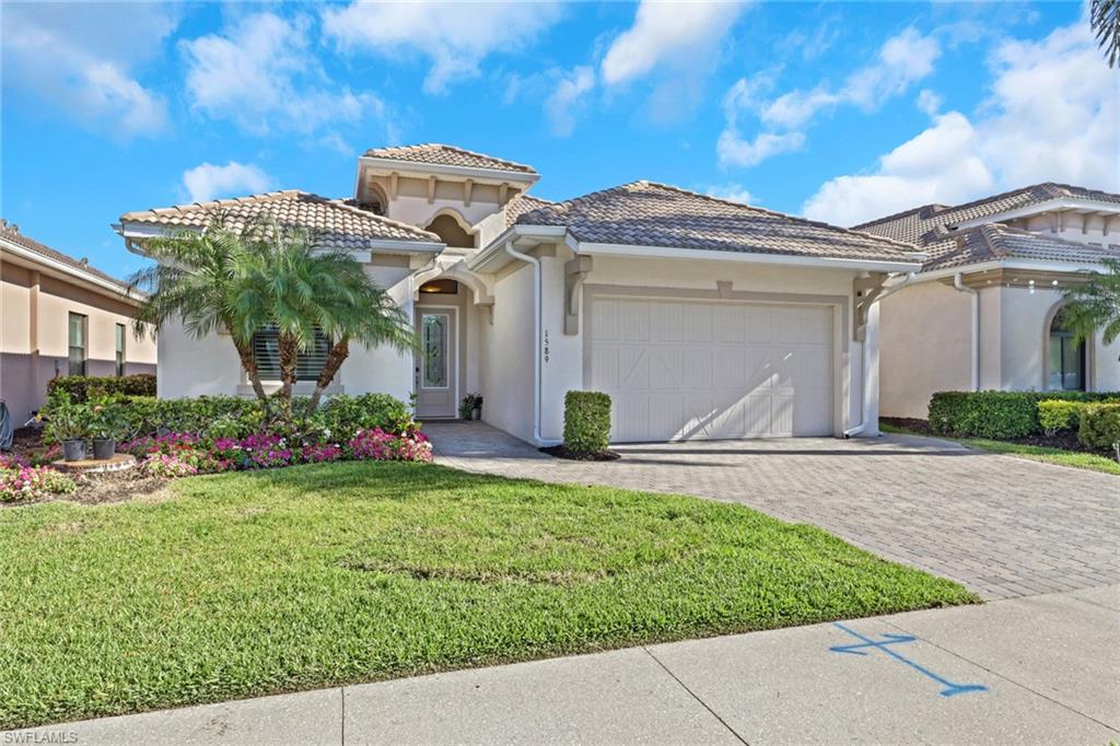 1589 Serrano Circle Naples, FL 34105 - Photo 2 of 38 a front view of a house with garden