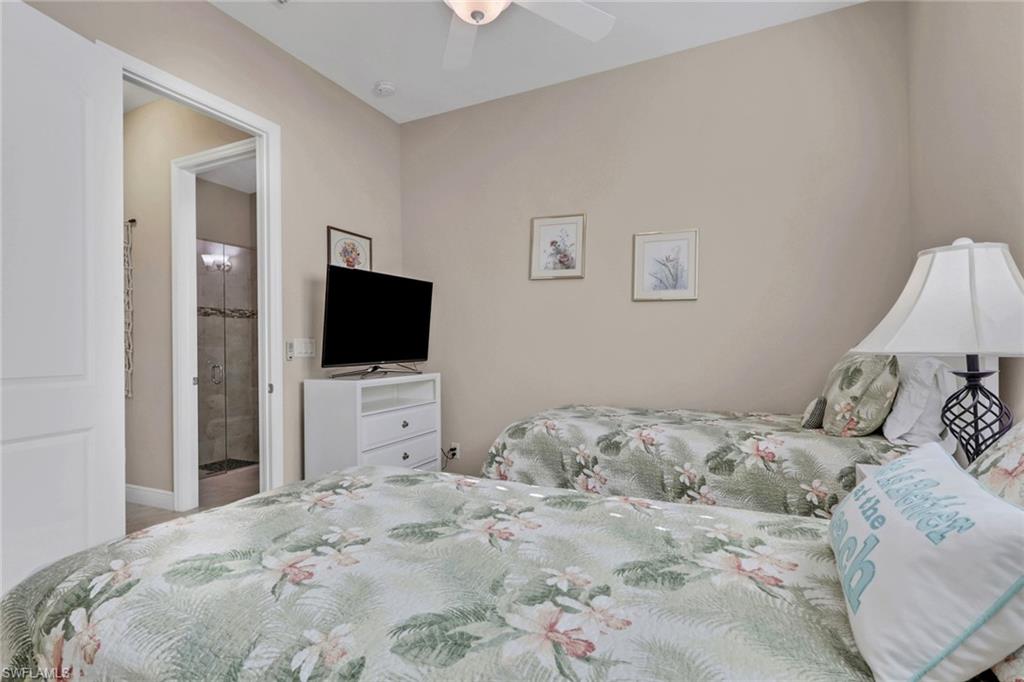1589 Serrano Circle Naples, FL 34105 - Photo 21 of 38 a bedroom with a bed and a flat screen tv