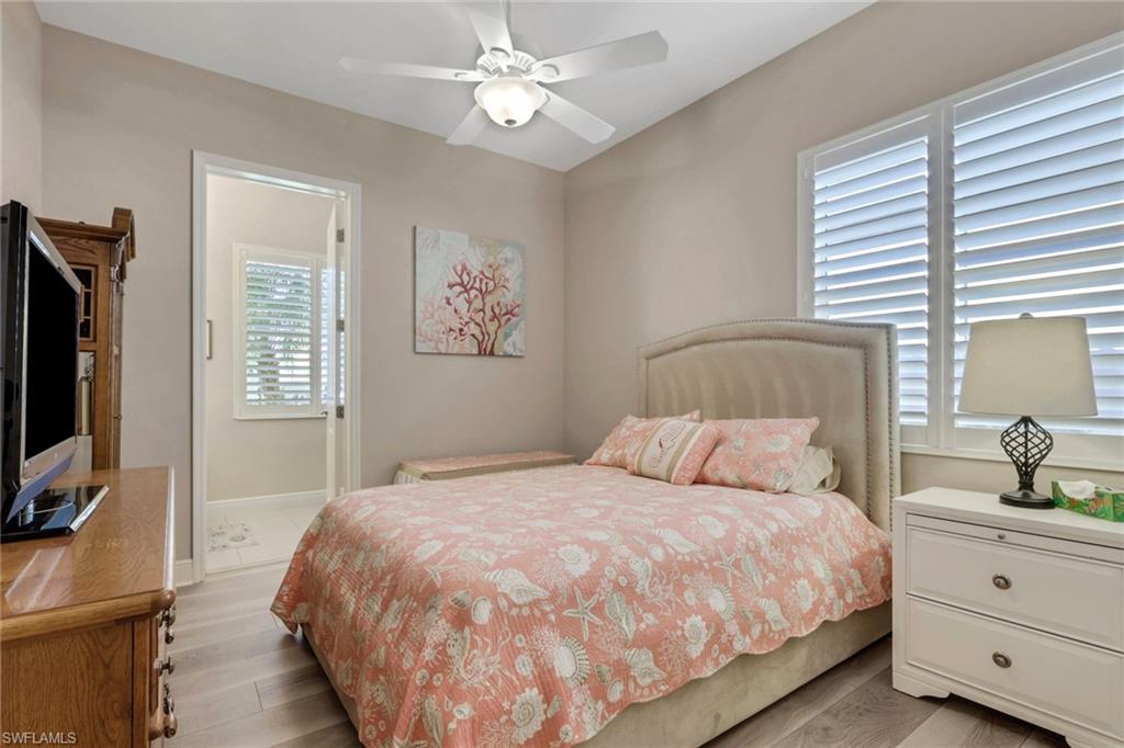 1589 Serrano Circle Naples, FL 34105 - Photo 23 of 38 a bedroom with a large bed and a flat tv screen on dresser