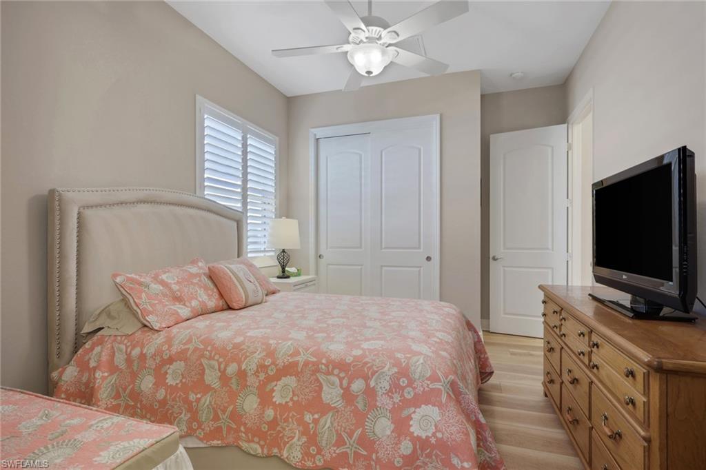 1589 Serrano Circle Naples, FL 34105 - Photo 24 of 38 a bedroom with a bed and a flat screen tv