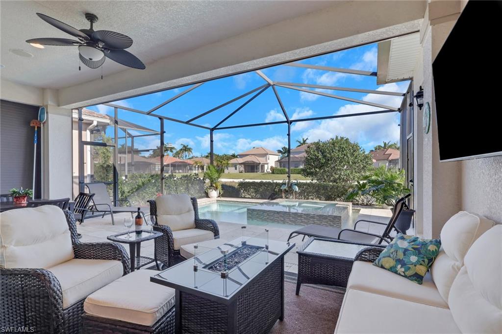 1589 Serrano Circle Naples, FL 34105 - Photo 28 of 38 a living room with patio furniture and a flat screen tv