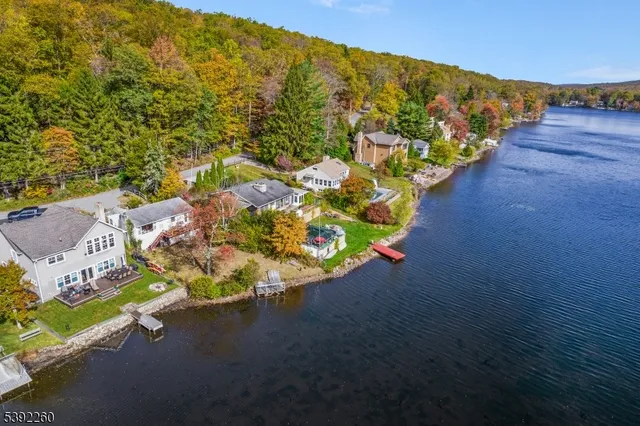 an aerial view of a house with a yard and lake view