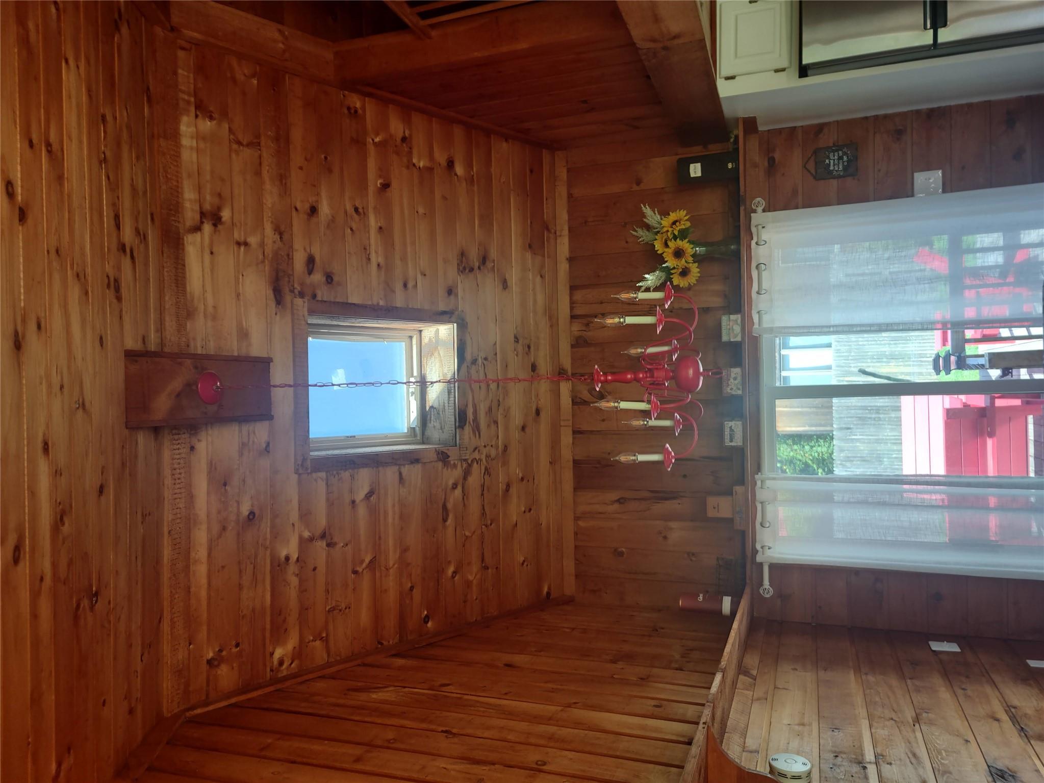 1139 State Rt 17B Mongaup Valley, NY 12762 - Photo 29 of 35 Detailed view of wood walls, wood ceiling, a chandelier, and refrigerator