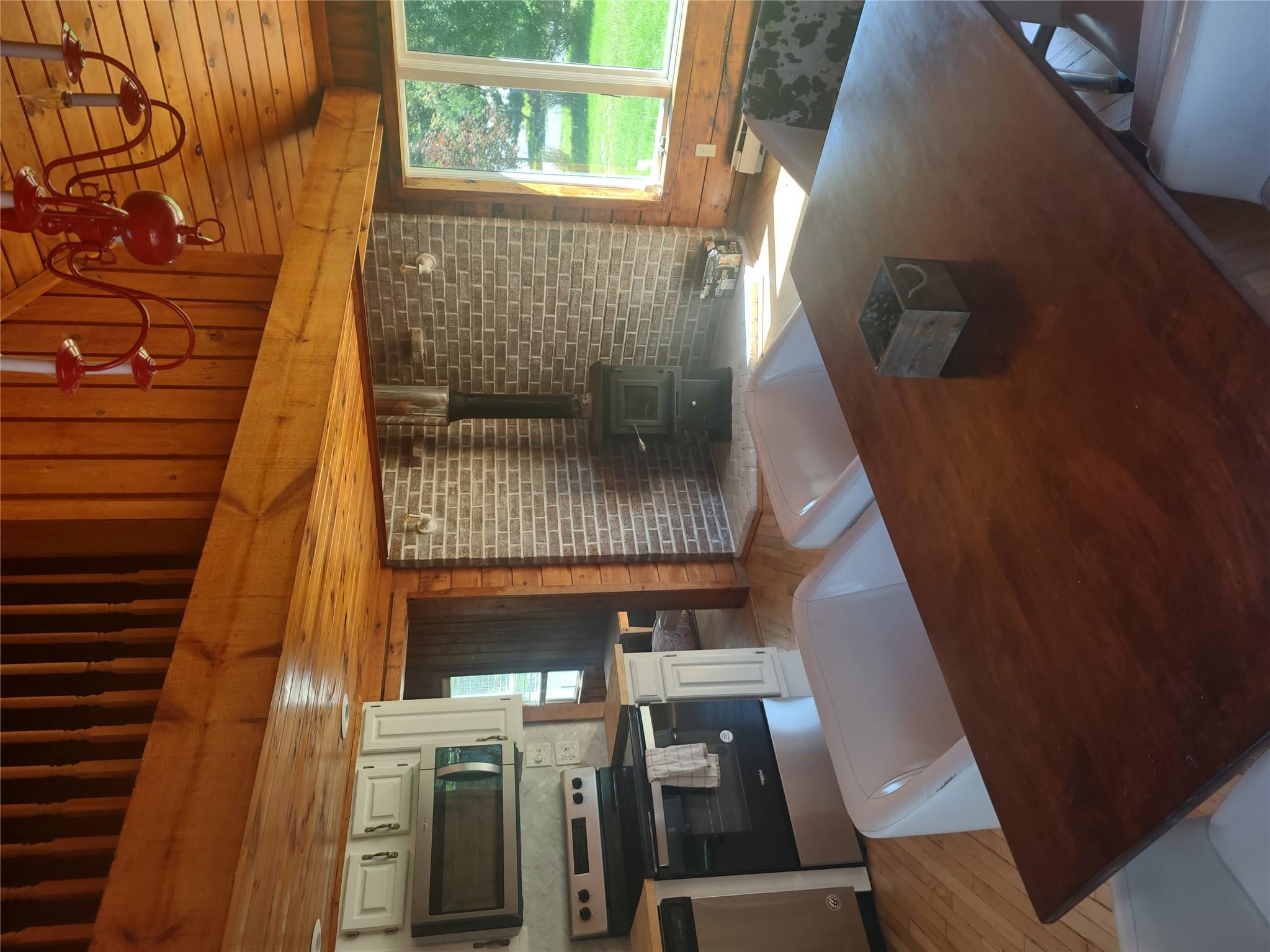 1139 State Rt 17B Mongaup Valley, NY 12762 - Photo 10 of 35 Kitchen with range, dishwasher, light wood finished floors, a chandelier, and wood walls