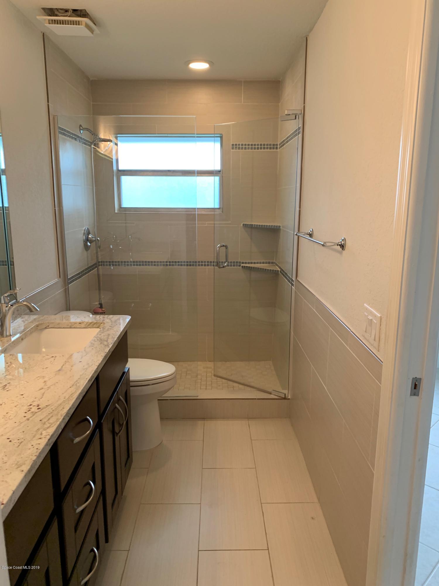 131 13th Avenue Indialantic, FL 32903 - Photo 18 of 23 a bathroom with a granite countertop sink a toilet and a shower