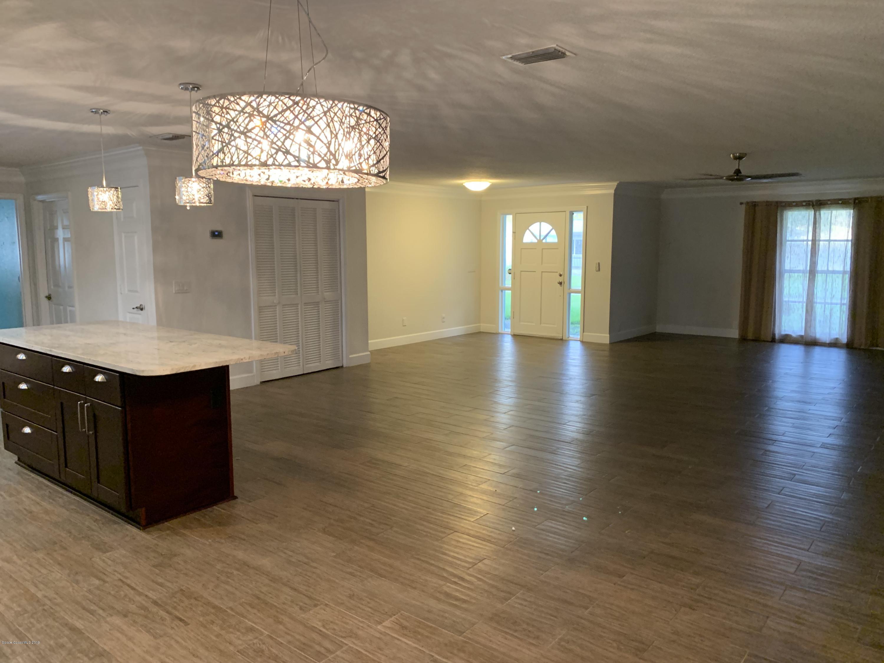 131 13th Avenue Indialantic, FL 32903 - Photo 5 of 23 a view of a hallway with wooden floor and chandelier
