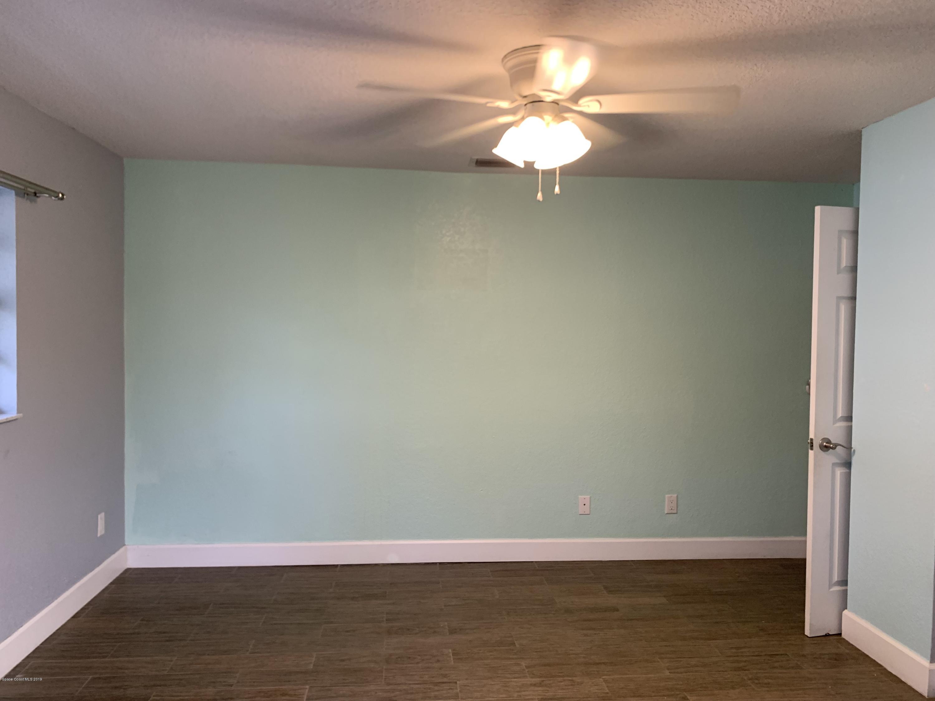 131 13th Avenue Indialantic, FL 32903 - Photo 7 of 23 a view of a room with wooden floor and a ceiling fan