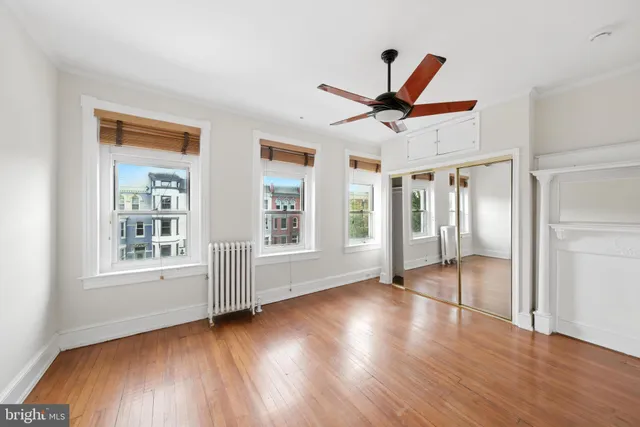 a view of a livingroom with wooden floor and a ceiling fan